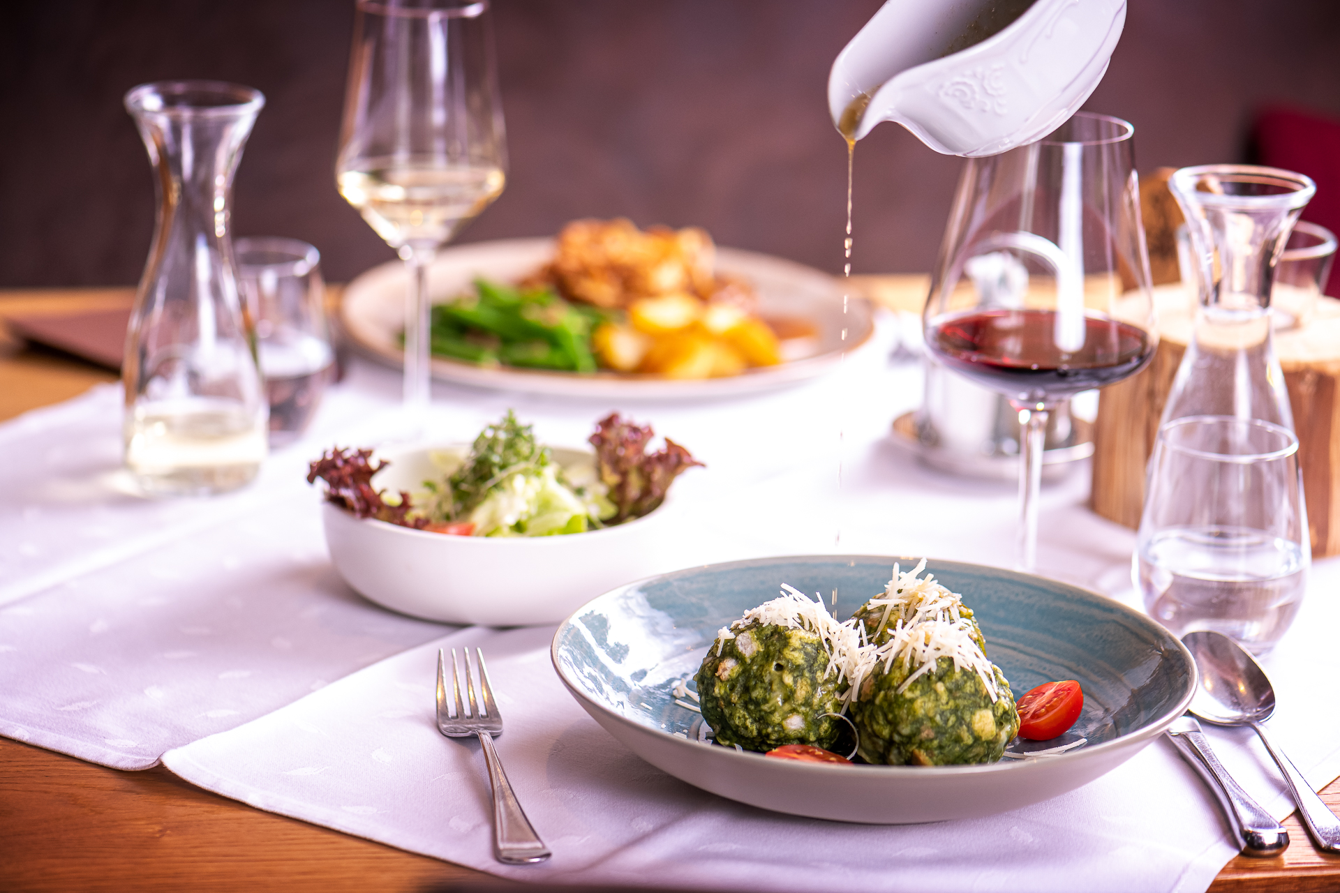 Gedeckter Tisch mit glutenfreien Spinatknödeln, Salat und Schnitzel