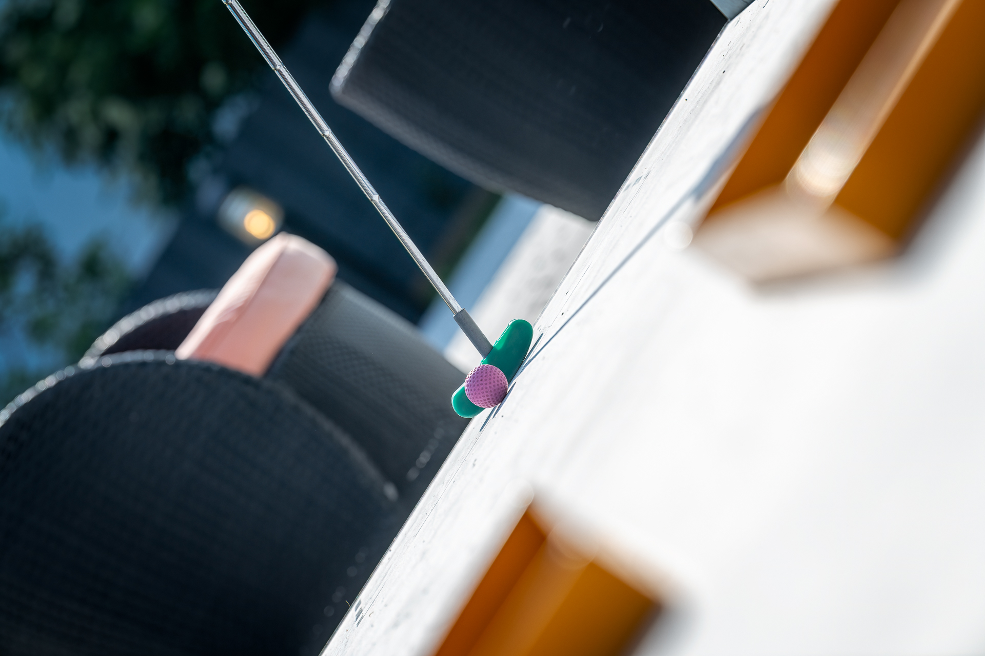 Mini golf club with a pink ball on the barrier